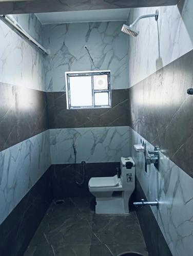 a bathroom with a white toilet and a window at hariholidaysvilla in Chennai