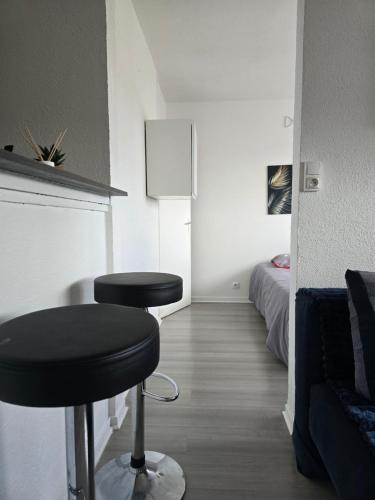 a room with two black stools and a bed at Le Stud in Belfort