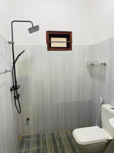 a bathroom with a toilet and a shower at Forest Edge Yala Resort in Gotamegama