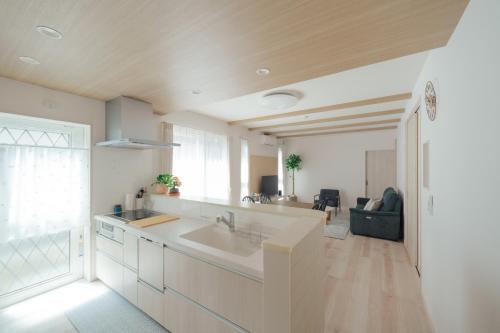 a kitchen with a sink and a living room at Quiet Japanese House near Airport in Kumamoto