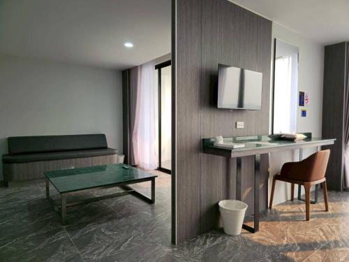 a room with a desk and a table and a chair at One Budget Hotel Chiangrai Chiangsaen 2 in Ban Wiang Nuea