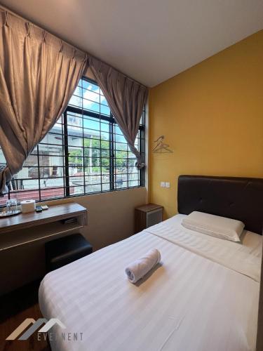 a bedroom with a bed with a towel on it at Everstay Inn by Evernent in Miri