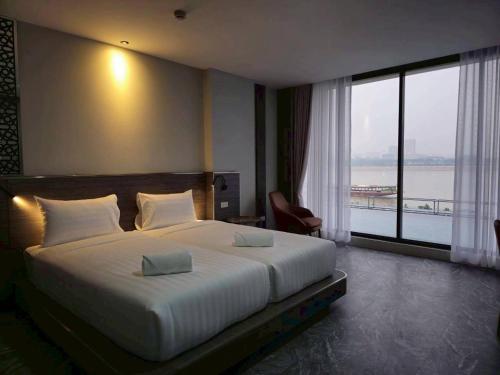 a bedroom with a large bed and a large window at One Budget Hotel Chiangrai Chiangsaen 2 in Ban Wiang Nuea