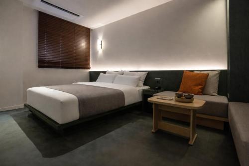 a bedroom with a bed and a couch at Daejeon Anook Hotel Yuseong Oncheon Station in Daejeon