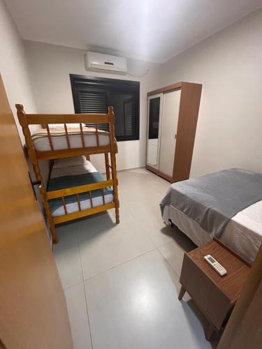 a room with a bed and a bunk bed and a table at Casa Mobiliada Conforto e Praticidade in Santa Rosa
