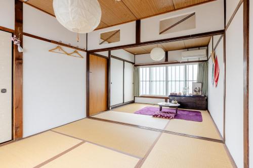 an empty room with a table in the middle of a room at Guest House Kominka Nagomi in Izumi-Sano