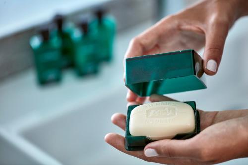 a person holding a bar of soap in their hands at Alti Santorini Suites - Caldera View in Megalochori