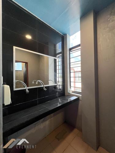a bathroom with a sink and a mirror at Everstay Inn by Evernent in Miri