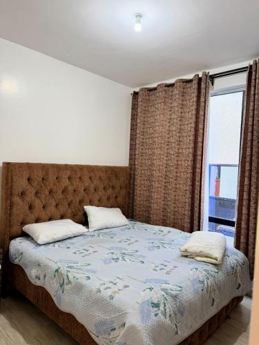 a bedroom with a bed with a large window at Easternville 4 bedroom Maisonette in Nairobi