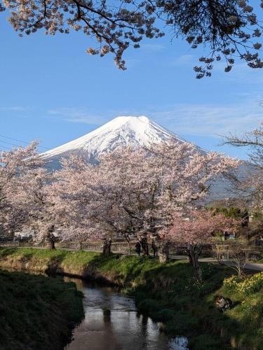 a snow covered mountain with a river and trees at Oshino Hakkai 1min Private Villa Mt Fuji View Fukujuen 福寿苑 in Oshino