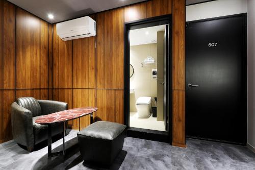 ein Badezimmer mit Toilette, Tisch und Stuhl in der Unterkunft Cielo HOTEL in Seosan