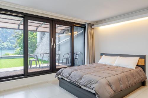 a bedroom with a bed and a large window at Chuncheon Rabbit Star Pension in Chuncheon