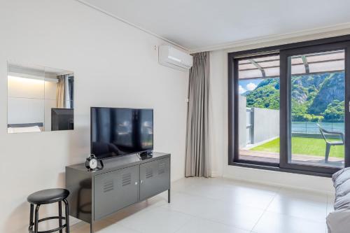 a living room with a tv and a large window at Chuncheon Rabbit Star Pension in Chuncheon
