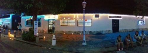 a group of people sitting in front of a building at night at Hotel Villa Ricaurte in Girardot