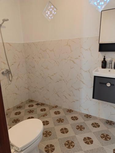 a bathroom with a toilet and a sink at Okasarna Guesthouse in Sidemen