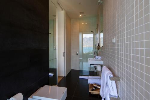 a bathroom with a toilet and a sink and a mirror at Aspen Grove by Sotheby's Luxury Rental Homes in Queenstown