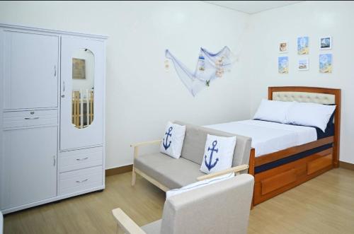 a small bedroom with a bed and a chair at Condotel in SM Trece Martires in Trece Martires