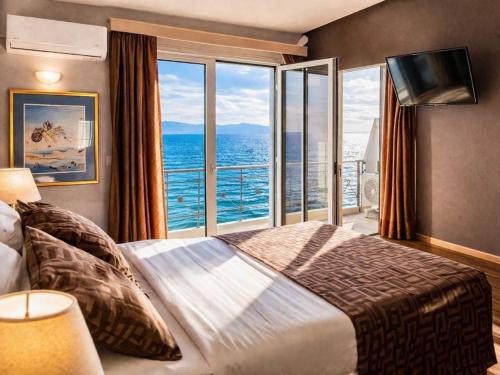 a bedroom with a large bed and a large window at Queens Leriotis Hotel in Piraeus