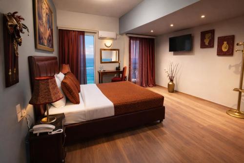 a hotel room with a bed and a desk at Queens Leriotis Hotel in Piraeus