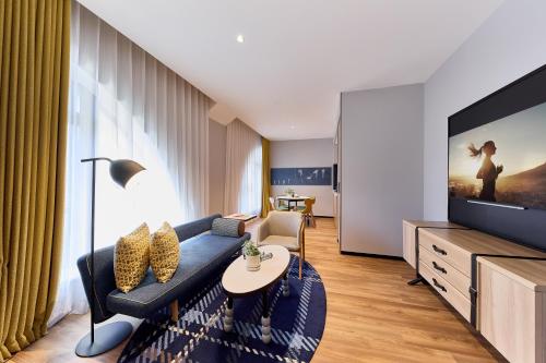 a living room with a blue couch and a tv at Citadines Namba Osaka in Osaka