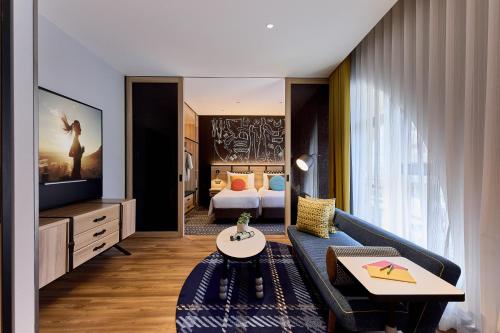 a living room with a couch and a bedroom at Citadines Namba Osaka in Osaka