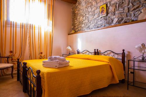 a bedroom with a yellow bed with towels on it at Casa Vacanze Caccamo Santa Lucia in Caccamo