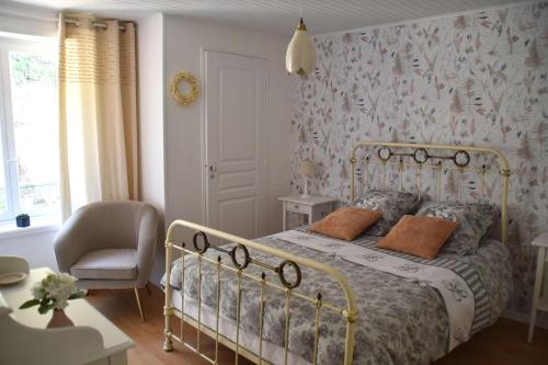 a bedroom with a bed and a chair at Gîte NAO in Serves-sur-Rhône