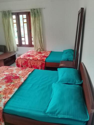 two beds sitting next to each other in a room at Oneli Homestay in Nuwara Eliya