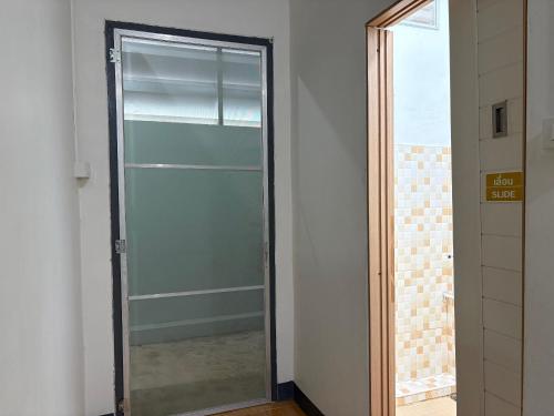 a glass door in a room with a window at Mama's Tree Homey Studio in Ban Klaeng Lang
