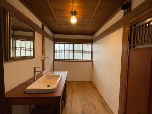a bathroom with a sink and a mirror at 国登録有形文化財の宿 Hotel 旧若林邸 in Sado