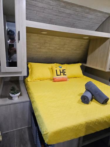 a bed with a yellow comforter and a life pillow at Pilot Glamp in Vieques