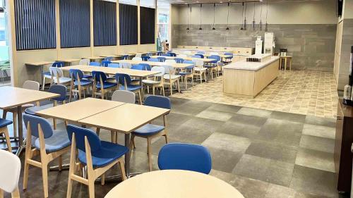 a classroom with tables and blue chairs in a cafeteria at Toyoko Inn Hokkaido Hakodate Ekimae Asaichi in Hakodate