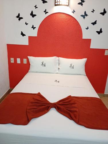 a bed with a red headboard with a bow tie on it at J Alejandro - Centro Histórico Guadalajara in Guadalajara
