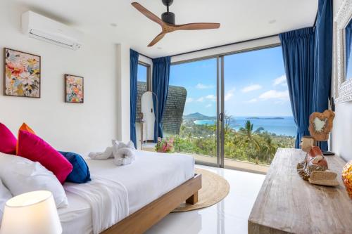 a bedroom with a bed and a large window at Villa The Wave in Chaweng Noi Beach