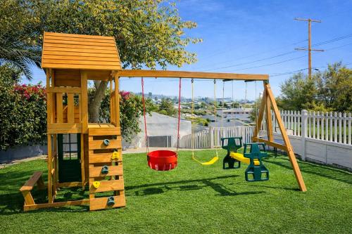 a playground with a wooden swing set in a yard at CasaViva Garden - 2BR with Firepit, S'mores & Kids Playset - Walk to Eats, Near Zoo, SeaWorld & Balboa Park in San Diego