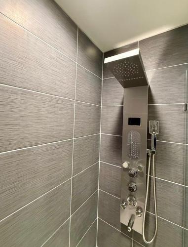 a bathroom with a shower with a phone in it at The Sandpearl in Stevensville