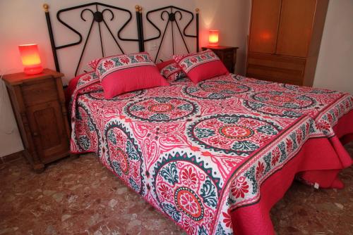 1 dormitorio con 1 cama con colcha roja y blanca en Maresto Calle Mar, en Salou