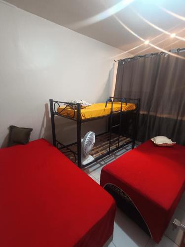 a room with two beds and a table in it at Eds pousada II in Juazeiro do Norte