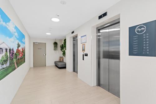 a hallway of a hospital with a sign on the wall at Direct Collective - Rhythm on Beach in Maroochydore