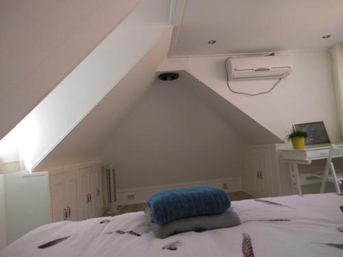 a bed with a blue pillow on it in a room at Vakantiehuisjes Marsherne in Poppingawier