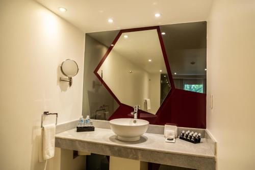 a bathroom with a sink and a large mirror at Hotel Casa Ciudad in Mexico City