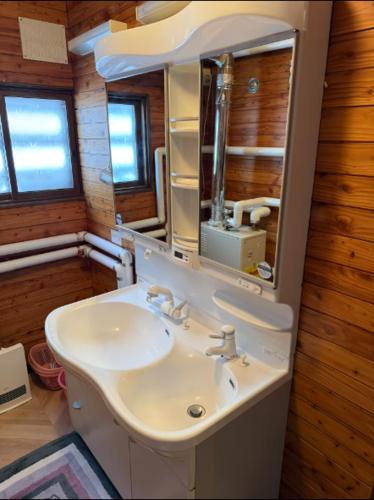a bathroom with a sink and a mirror at Yama Chalet in Rankoshi