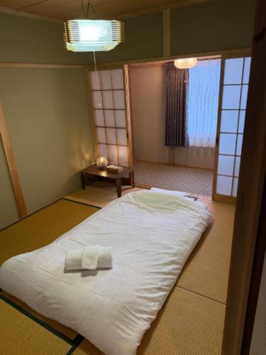 a bed in a room with two towels on it at Yama Chalet in Rankoshi