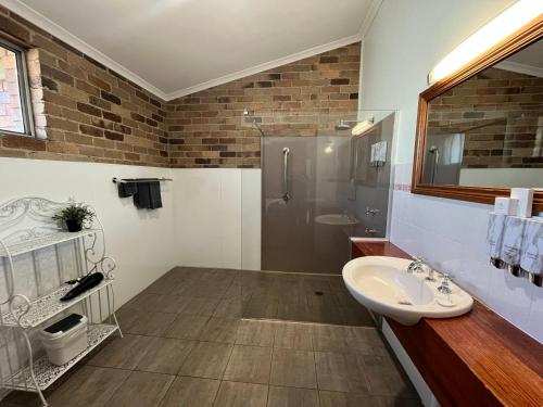 a bathroom with a sink and a shower at Rest Point Motor Inn in Glen Innes