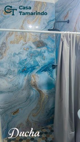 a shower curtain in a bathroom with a painting at Casa Tamarindo in Las Peñitas