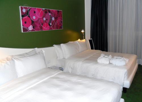 two beds in a hotel room with white sheets at Idea Hotel Milano Malpensa Airport in Case Nuove