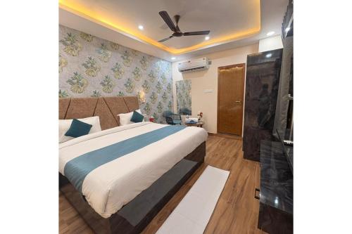 a bedroom with a bed and a ceiling fan at Hotel Raas Grand in Sachendi
