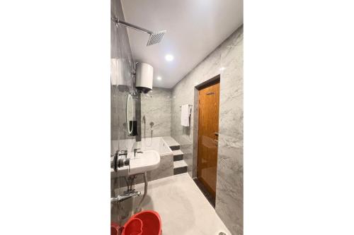 a bathroom with a sink and a bath tub at Hotel Raas Grand in Sachendi