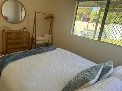 a bedroom with a bed with a mirror and a dresser at G & R Beach Cottage in Warnbro