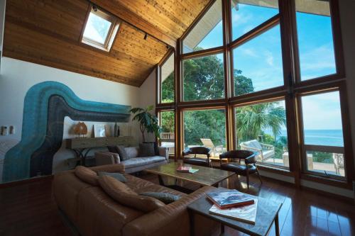 a living room with a couch and some windows at Monterey House by SANA in Tateyama